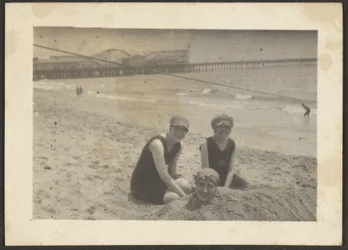[Femmes sur la plage enterrant une amie dans le sable]