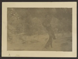 [Jeune homme avec chien dans un champ]