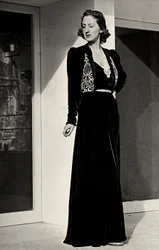Mannequin porte une longue robe de soirée en velours sombre avec décoration brodée, créée par la maison de couture italienne "Fercioni".