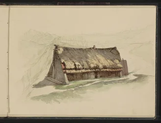 Grange avec un toit de chaume dans un pré