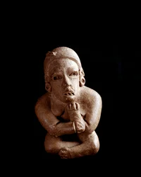 Statuette en argile représentant une femme assise, bras et jambes croisés