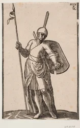 Soldat debout, vu de face; coiffure avec un sommet haut et fin; dans la main droite une lance, sur le bras gauche un bouclier vu de l