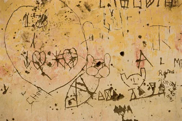 Graffiti gravé sur un vieux mur en plâtre extérieur.