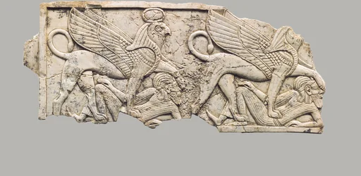 Plaque de meuble sculptée en relief avec deux sphinx à tête de faucon piétinant des captifs, 9e-7e siècle av. J.-C.