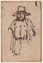 Un homme debout portant un chapeau à larges bords