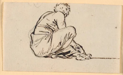 Un homme accroupi, vu de côté