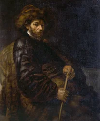 Un homme assis avec un bâton