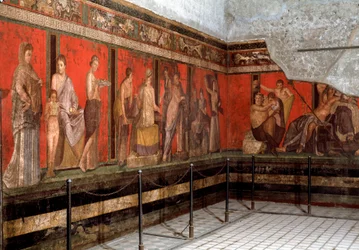 Initiation au culte de Dionysos : un jeune homme est initié au culte, lit le rituel, et un petit garçon fait une offrande. Ier siècle av. J.-C. Fresque de la villa des Mystères à Pompéi, Italie