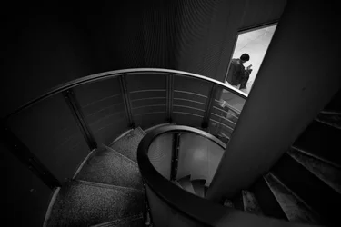 Une silhouette solitaire dans un escalier en colimaçon