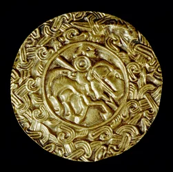 Archéologie du Moyen Âge : art barbare de Lombardie : disque en or. Au centre, un saint à cheval avec une lance et autour des motifs animaliers. Art lombard, vers 600. Italie, Cividale del Friuli, Musée Archéologique
