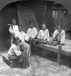 Femmes birmanes fumant devant leur maison, Mandalay, Birmanie, 1908