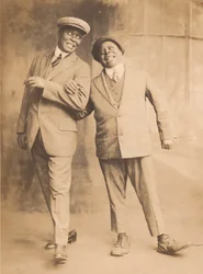 Photographie de deux hommes se tenant par le bras