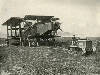 Un petit tracteur motorisé mettant en position une énorme machine de bombardement de la RAF, 1919
