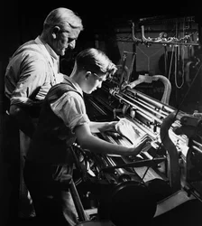 Un maître forme un jeune apprenti au tricotage mécanique, Lyle et Scott, Hawick