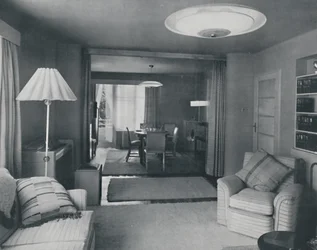Salle à manger et salon, séparés uniquement par de lourds rideaux dans un tissage moderne attrayant