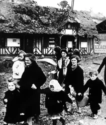 Familles quittant leur village bombardé pendant le débarquement de Normandie, France, 1944