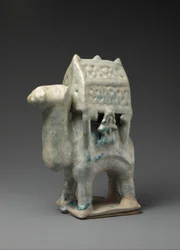 Figurine en forme de chameau portant un palanquin et deux cavaliers