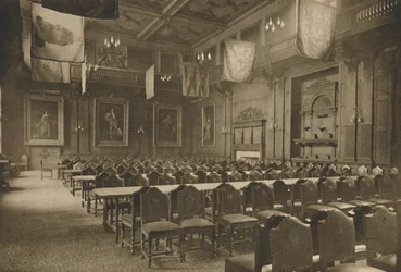Grande salle décorée de drapeaux où la puissante compagnie des épiciers tient ses banquets, vers 1935