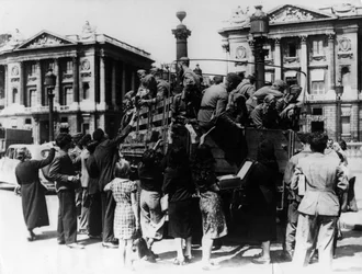 Vendeurs de rue français offrant des souvenirs à un camion de soldats allemands, Paris, 27 juillet 1940