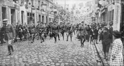 Le général Currie et les troupes canadiennes traversant une ville libérée