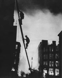 Sortie pendant le Blitz, silhouettés contre la lumière des incendies, des sauveteurs grimpent dans un bâtiment à St.