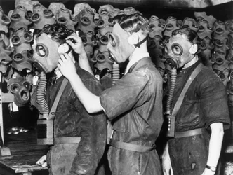 Trois hommes portant des masques à gaz, vers 1930