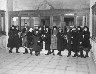 États-Unis : vers 1926 Un groupe de femmes debout aux guichets 