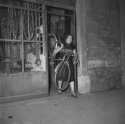 Cycliste Alfonsina Strada (Alfonsa Rosa Maria Morini) sortant de son magasin au 80 rue Varesina, Milan, Italie