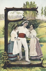 E : Un homme vêtu de blanc et rouge se tient debout entre deux femmes portant jupe, corsage et tablier. Décor champêtre - Alphabet personnages Ref Th. E., L. Theochrom - Série 994. Theodor Eisman, éditeur, Leipzig