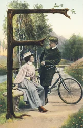 F : Un homme en tenue de cycliste et appuyé sur sa bicyclette discute avec une femme assise sur un banc. Décor champêtre - Alphabet personnages Ref Th. E., L. Theochrom - Série 994. Theodor Eisman, éditeur, Leipzig