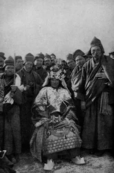 Tibet. Magicien en tenue complète et un groupe de moines admiratifs. 1920