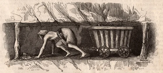 Une fille enchaînée à un chariot plein de charbon et le traînant dans une mine de charbon anglaise