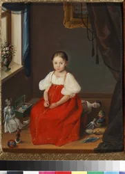 Portrait de petite fille en robe rouge posant parmi ses jouets