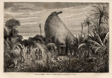 La place du chef Mango, une habitation de guerrier qui se distingue par sa hauteur, la sculpture du tabou qui surmonte le toit et les piliers de la porte, ainsi que par les peaux humaines fixées sur de longs poteaux à l