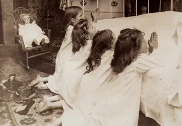Quatre petites filles agenouillées au bord d