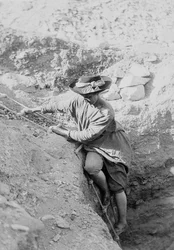Hilda Petrie (née Urlin) descendant par une échelle de corde dans un puits de tombeau, peut-être à Denderah