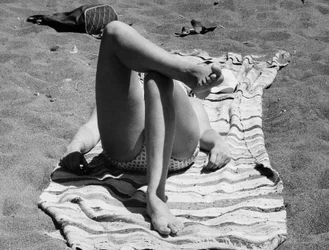 Jambes féminines sur une plage, vers 1960 (photo n/b)