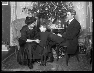 Dan Seymour et sa famille en pose informelle, assis sous un sapin de Noël, Noël 1912