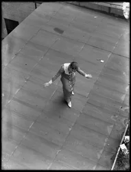 Sténographe sur le toit avec les bras écartés comme si elle saluait, 22 août 1914