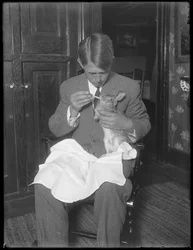 James H. Hassler nourrissant un lapin, vers 1912