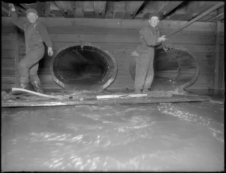 Hommes travaillant dans les égouts de la rue W. 129th, New York