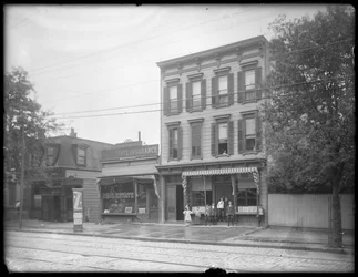 Sept enfants posent devant une branche non identifiée de la bibliothèque publique de Queens Borough, New York, vers 1910