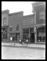 Trois garçons non identifiés devant la boutique de harnais de Fleming, peut-être Cochranton, Pennsylvanie, vers 1913