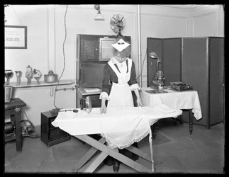 Jeune femme en costume de servante démontrant l