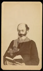 [Homme non identifié, chauve et barbu, lisant assis].