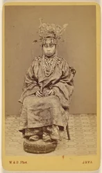 [Femme javanaise portant une coiffe ornée, assise]